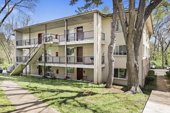 Front view of a three-story apartment building with outdoor staircases.