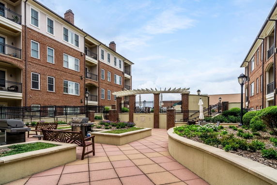 Front view of a brick apartment complex with a central courtyard area.