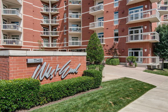 Front view of a multi-story brick apartment building with balconies.