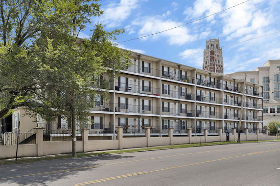 Front view of a multi-story apartment building with balconies.