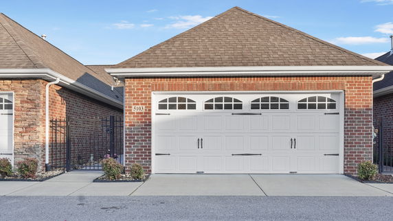 Front view of a brick house with a white garage door.