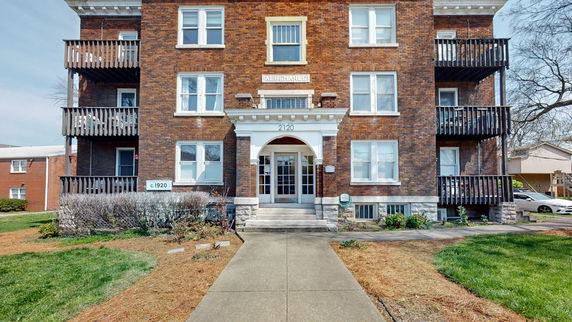 Front view of a brick apartment building with multiple balconies.