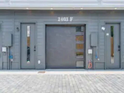 Front view of a building with a garage and two entry doors.