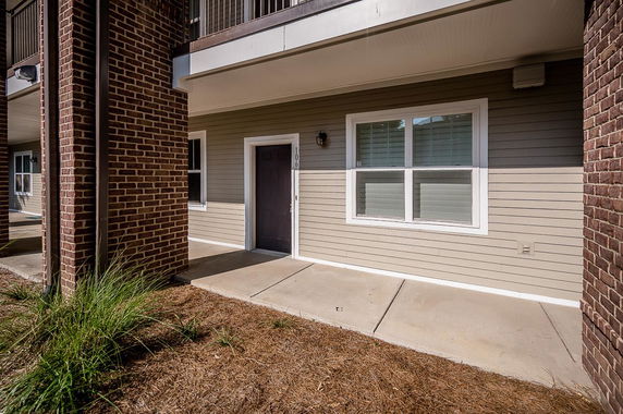 Front view of a building entrance with brick and siding exterior.