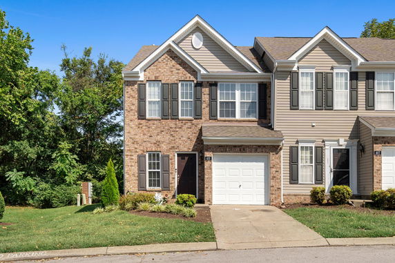 Front view of a two-story house with brick facade and a single garage.