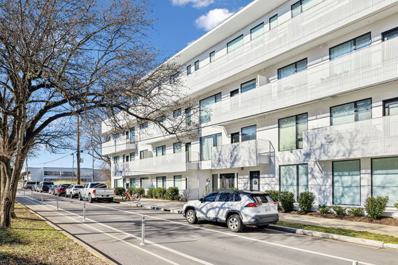 Front view of a modern multi-story building with balconies.