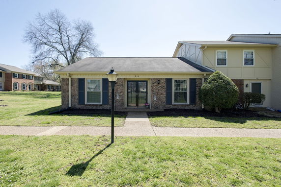 Front view of a single-story house with brick exterior and a central entrance.