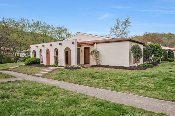 Front view of a single-story house with arched features and a small porch.