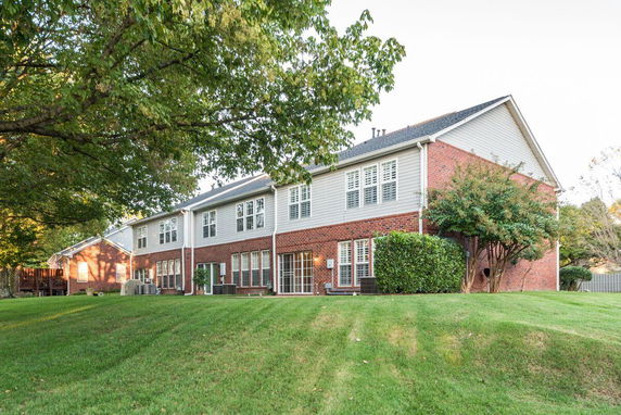 Rear view of a two-story brick house with multiple windows.