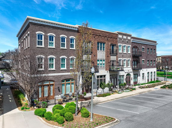 Front view of a multi-story brick building with arched windows.