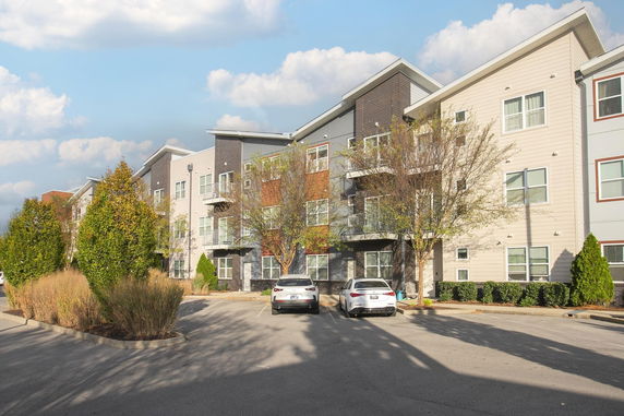 Front view of a multi-story apartment building with balconies.