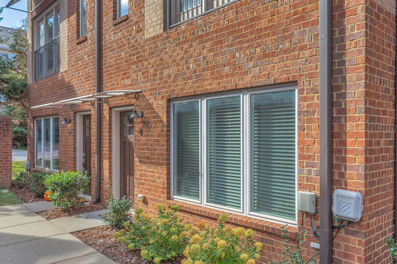 Front view of a brick townhouse with windows and a door.