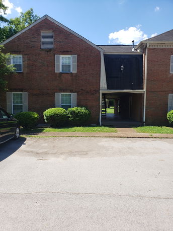 Front view of a two-story brick building with windows and a central entrance.