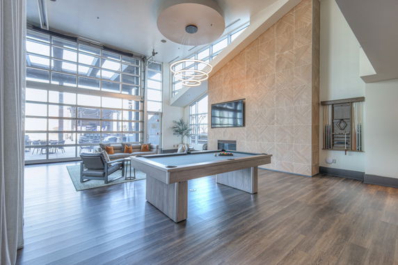 Interior view of a modern game room with a pool table and lounge seating.