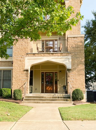 Front view of a building with an entrance and a balcony above.