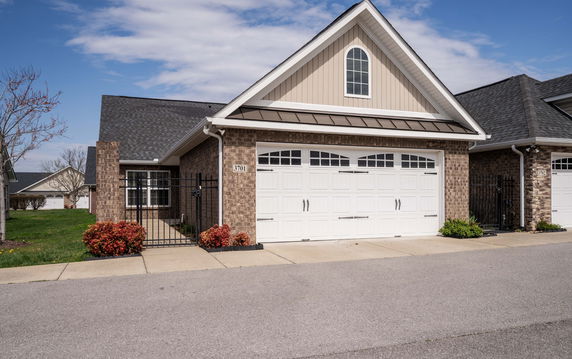 Front view of a house with a white double garage and brick exterior.