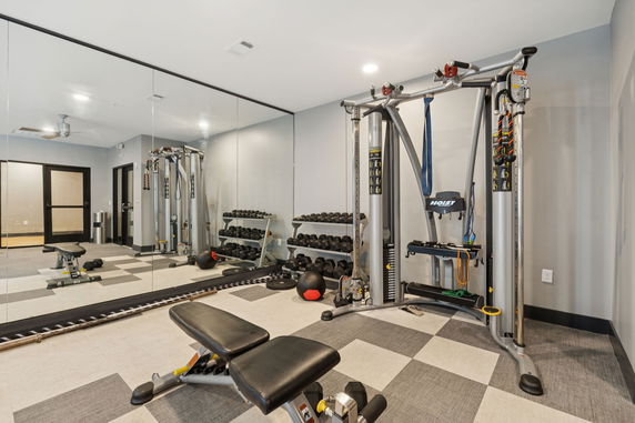 Interior view of a gym with exercise equipment and mirrors.