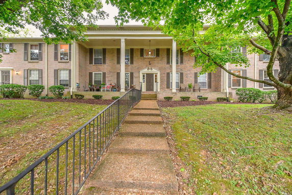 Front view of a two-story brick house with a central entrance and columns.