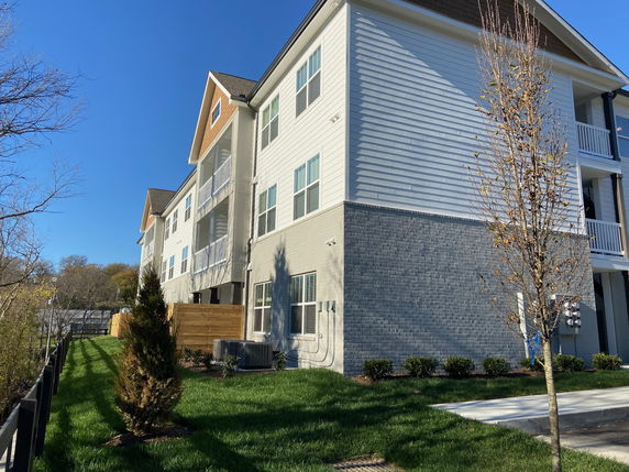 Side view of a multi-story residential building with balconies.