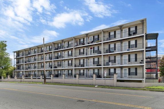 Front view of a multi-story apartment building with balconies.