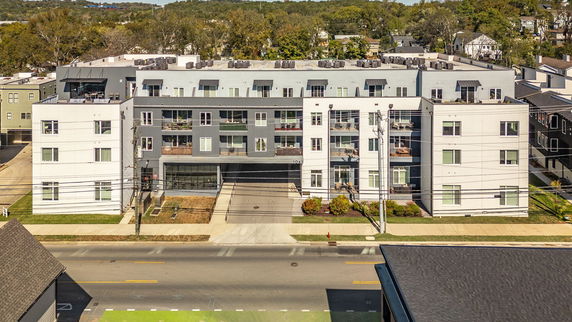 Front view of a multi-story modern building with a central drive-through.