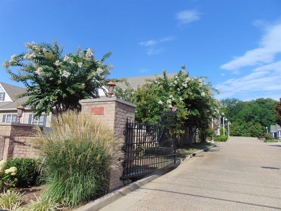 Front view of a house with a gated entrance and brick walls.