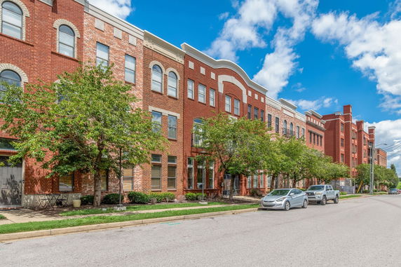 Front view of a multi-story brick building with various window designs.