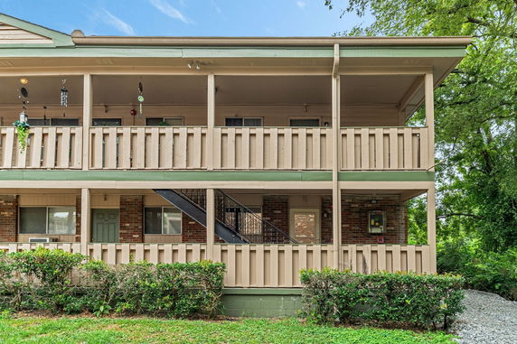 Front view of a two-story building with balconies and exterior stairs.
