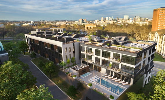 Aerial view of a modern multi-story residential building with a rooftop garden and pool area.