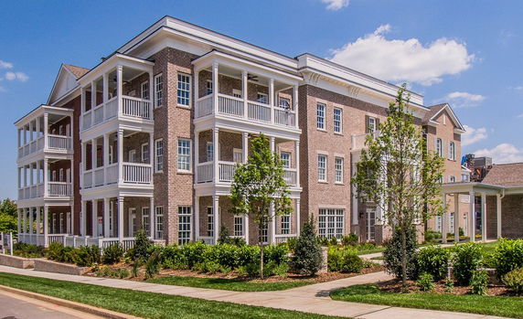 Front view of a multi-story brick building with balconies.
