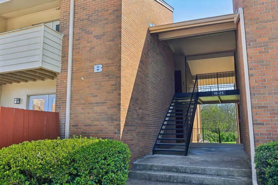 Front view of a brick building with an exterior staircase leading to the upper floors.