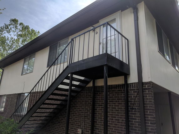 Front view of a two-story building with an exterior staircase.
