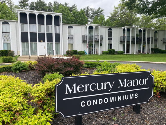 Front view of a two-story condominium building with arched windows.