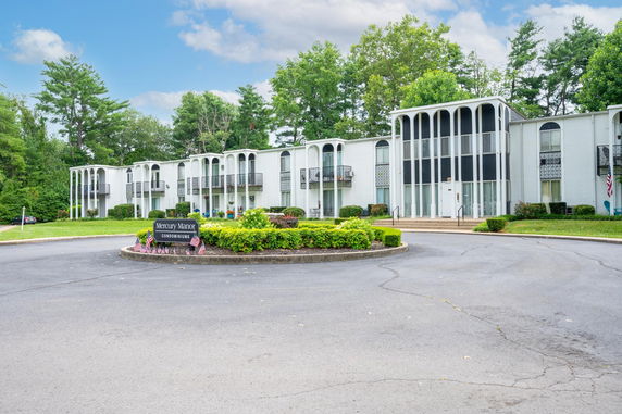 Front view of a condominium building with a modern design and a central entrance.
