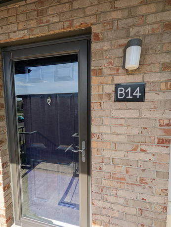 Front view of a building entrance with a glass door and a 'B14' sign.