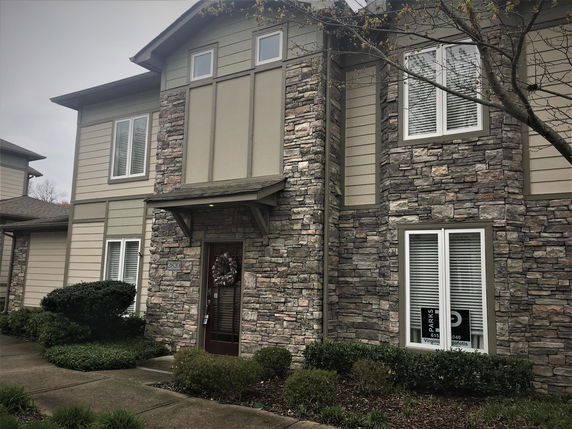Front view of a two-story house with stone and siding exterior