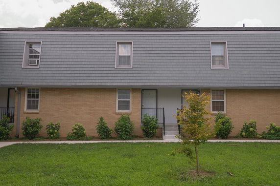 Front view of a two-story building with brick and shingle exterior.