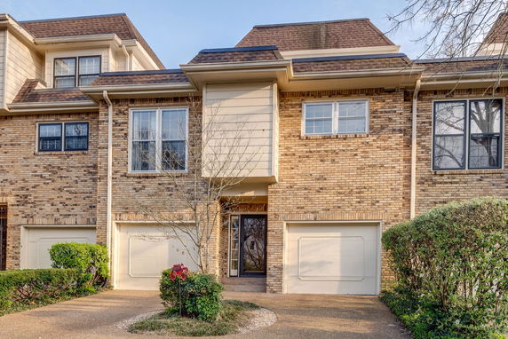 Front view of a two-story brick house with an attached double garage.