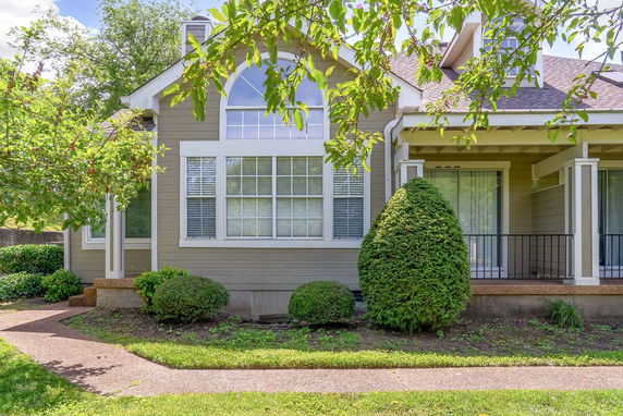 Front view of a house with multiple windows and a small porch area.