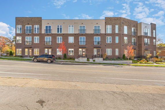 Front view of a three-story apartment building with multiple balconies.