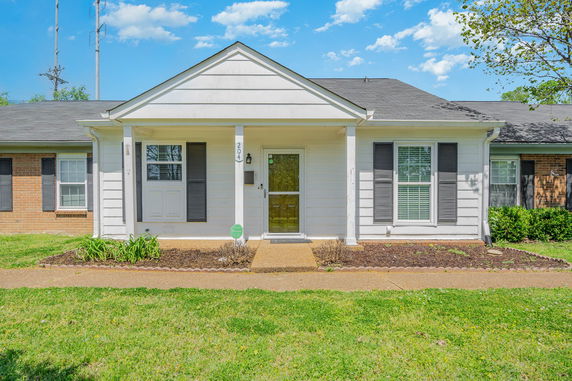 Front view of a single-story house with white siding and dark shutters.