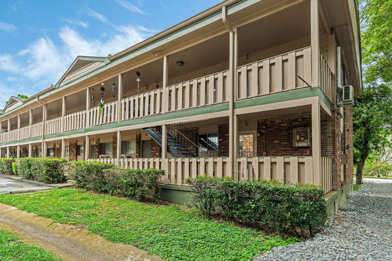 Front view of a two-story building with balconies and brick facade.