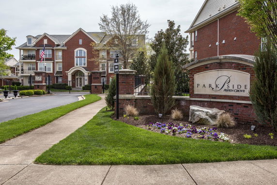 Front view of a multi-story brick building with a gated entrance.