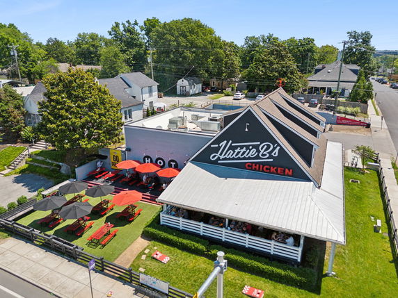 Front view of a restaurant building with a gable roof and outdoor seating area.