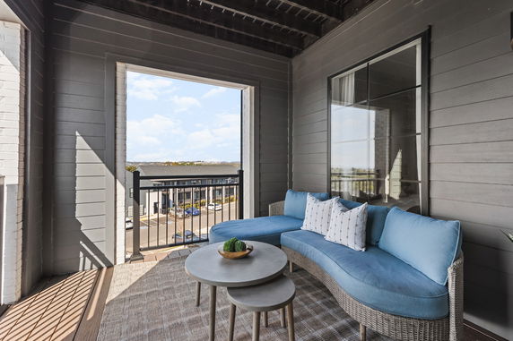 Balcony view with outdoor seating and a view of surrounding buildings.