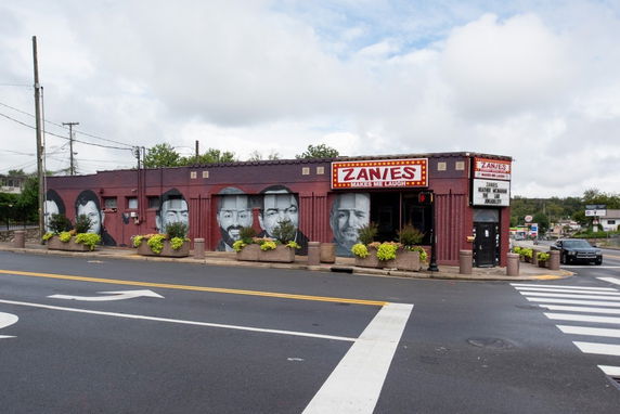 Front view of a low-rise building with murals and signage.