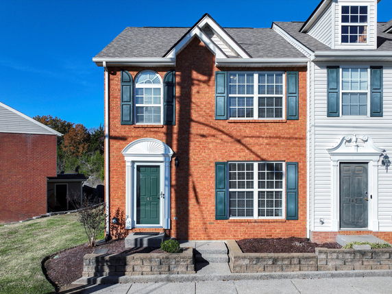 Front view of a two-story house with a mixture of brick and siding exterior.