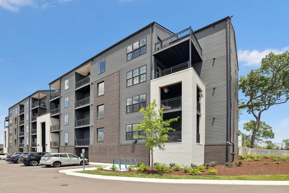 Front view of a multi-story modern apartment building with balconies.