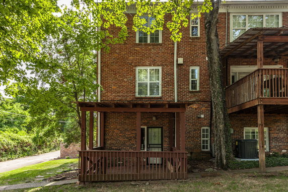 Front view of a brick multi-story house with wooden balconies.