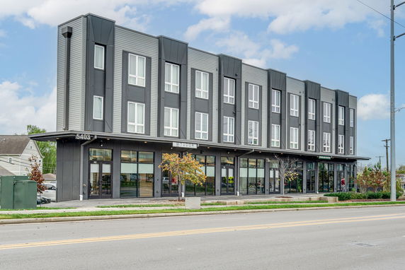 Front view of a modern three-story commercial building with large windows.